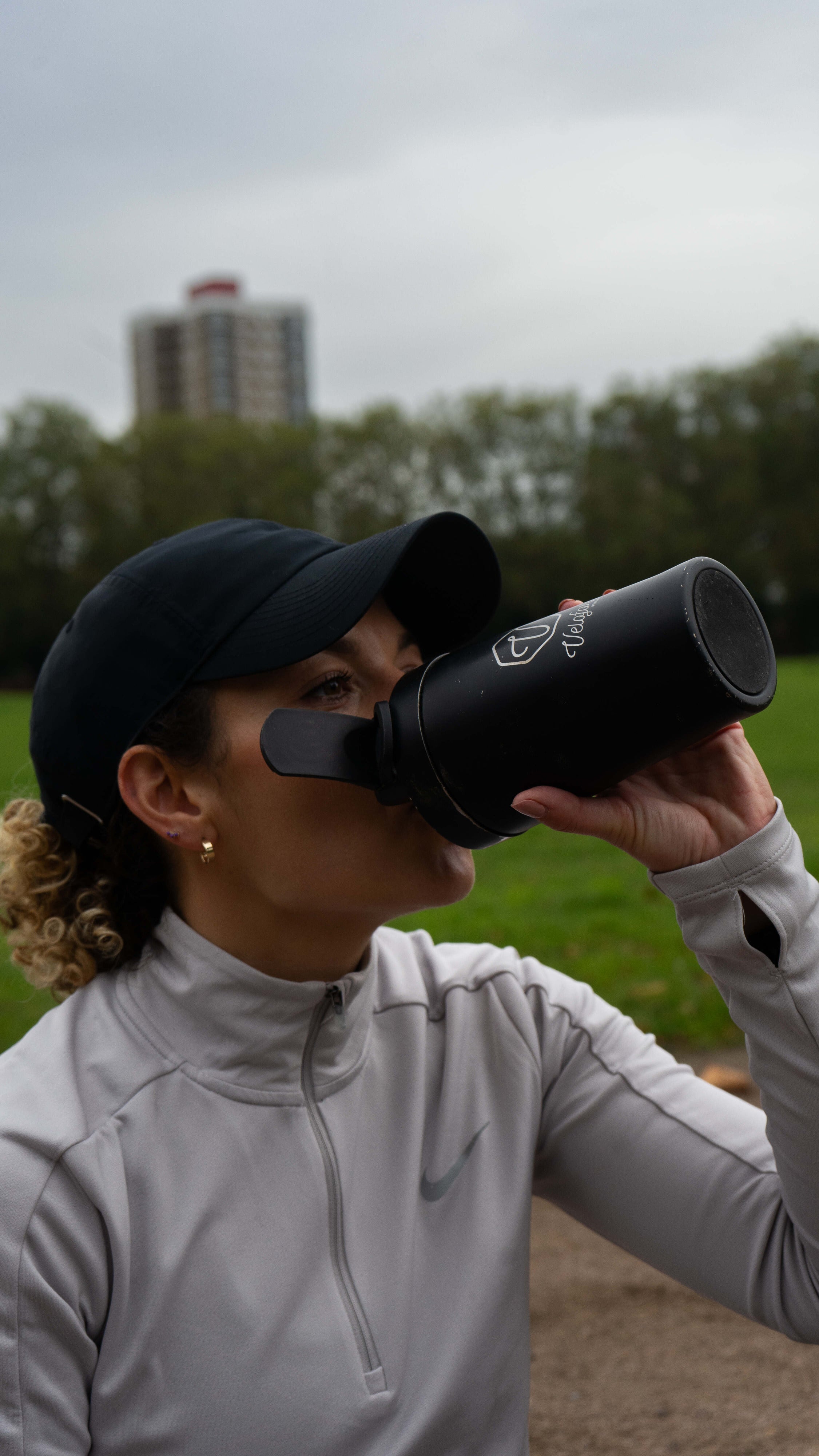 A woman drinking from a protein shaker