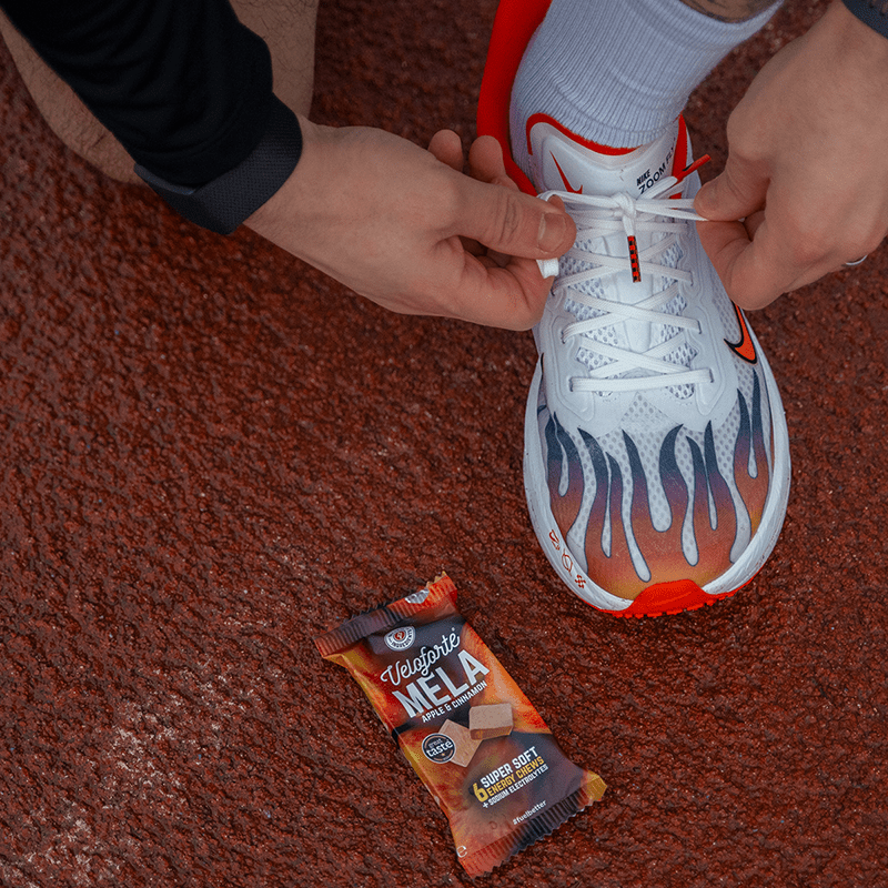 Runners foot on a track next to Mela Energy Chews