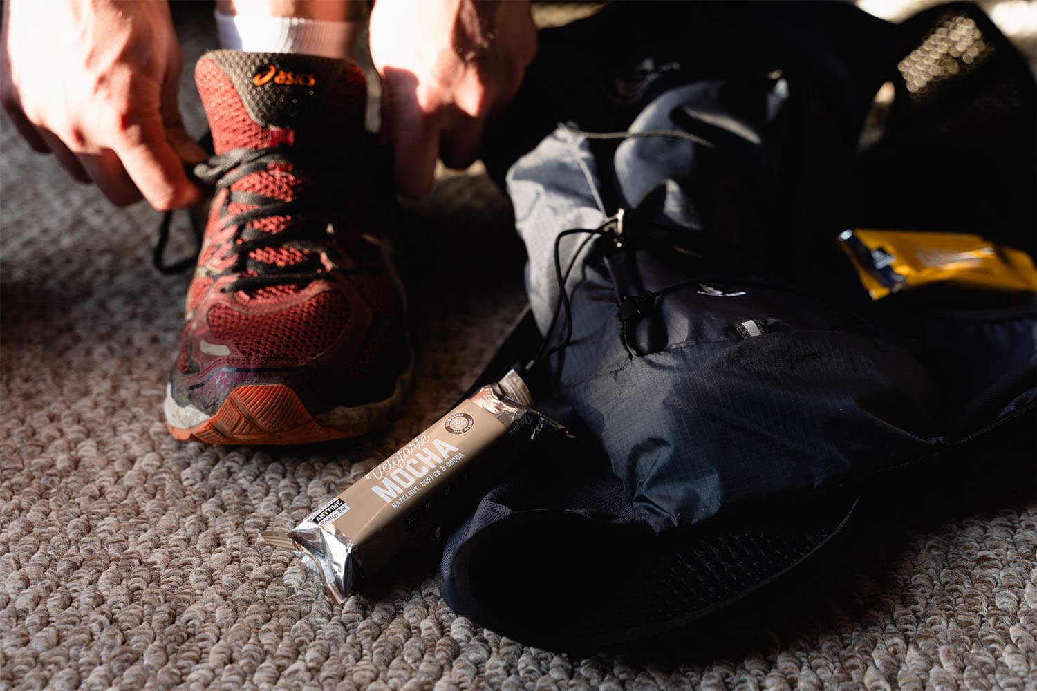 Man preparing shoes and energy bar