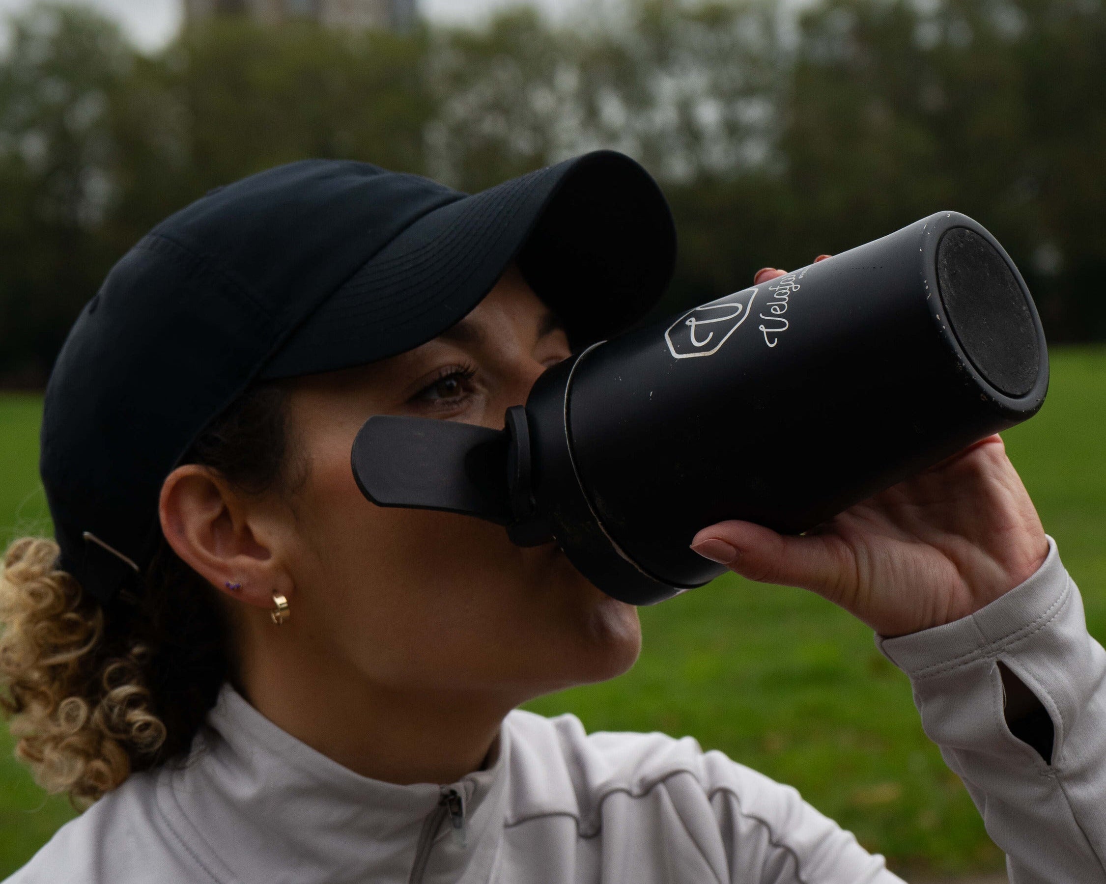 A woman drinking from a protein shaker