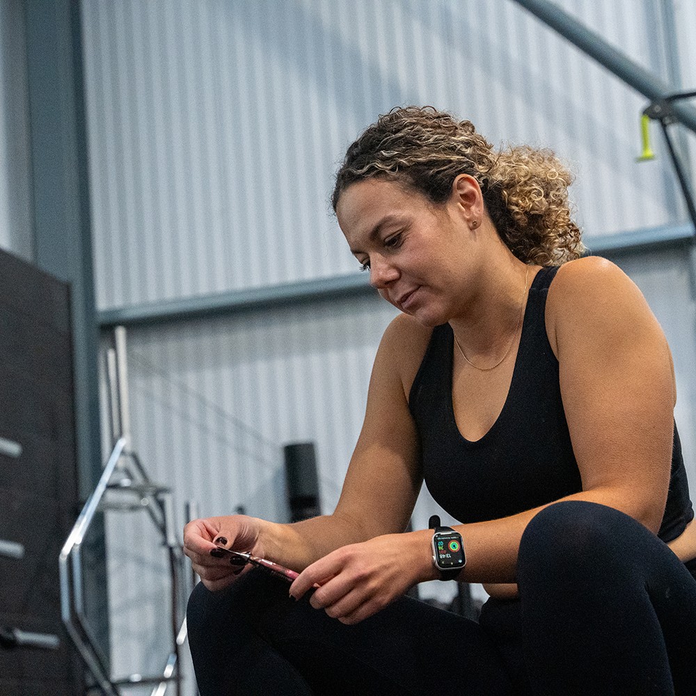 woman in a gym holding an energy gel