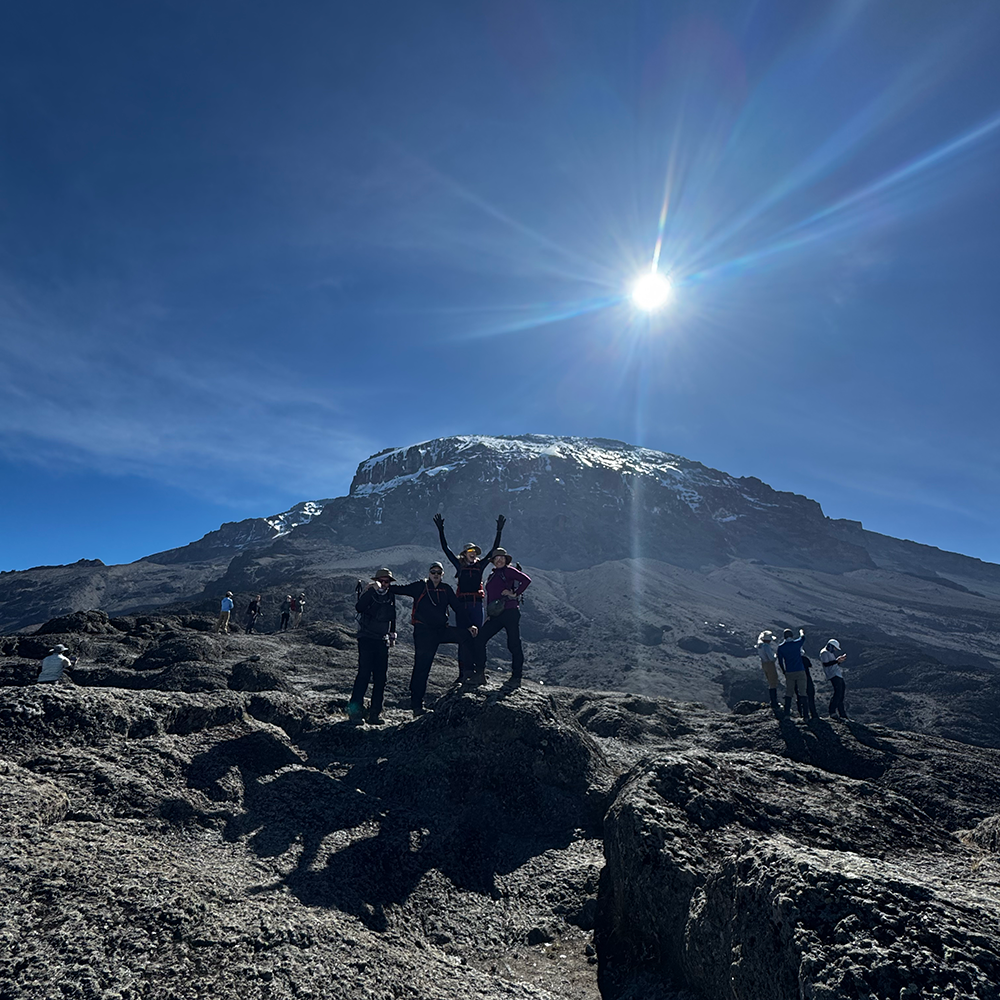 a team of people at the top of Kilimanjaro