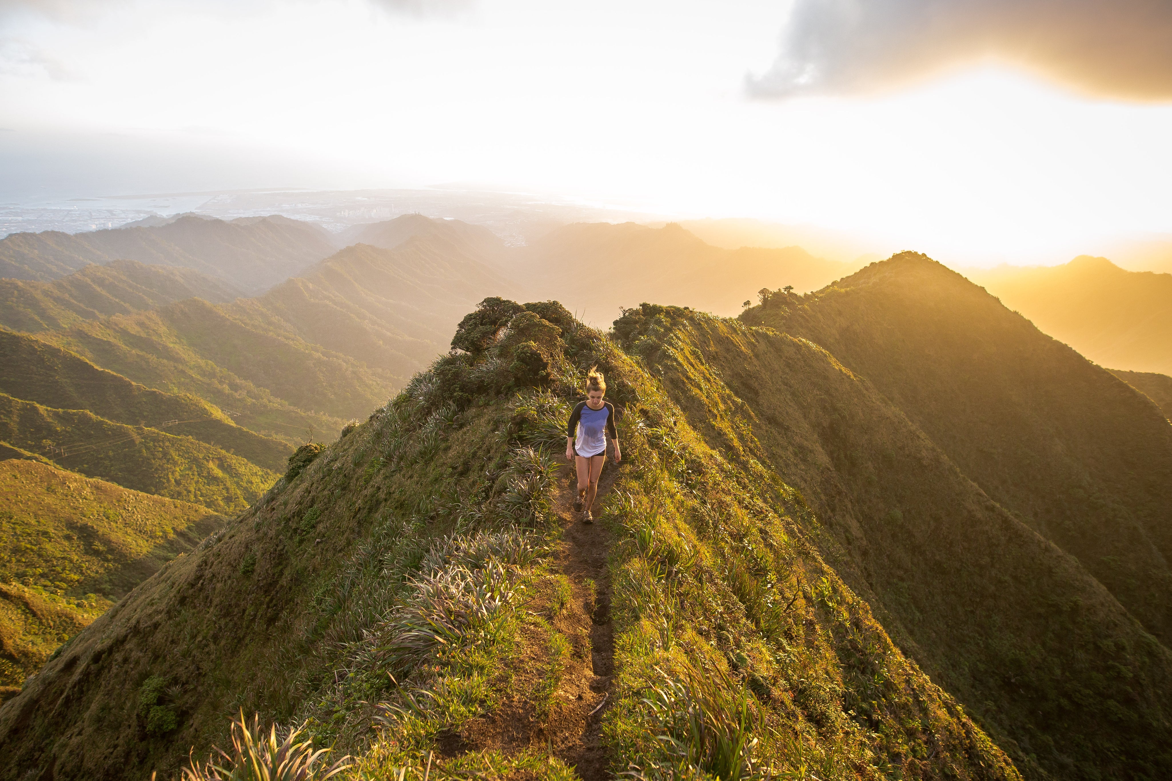 A woman is walking on a hilltop.