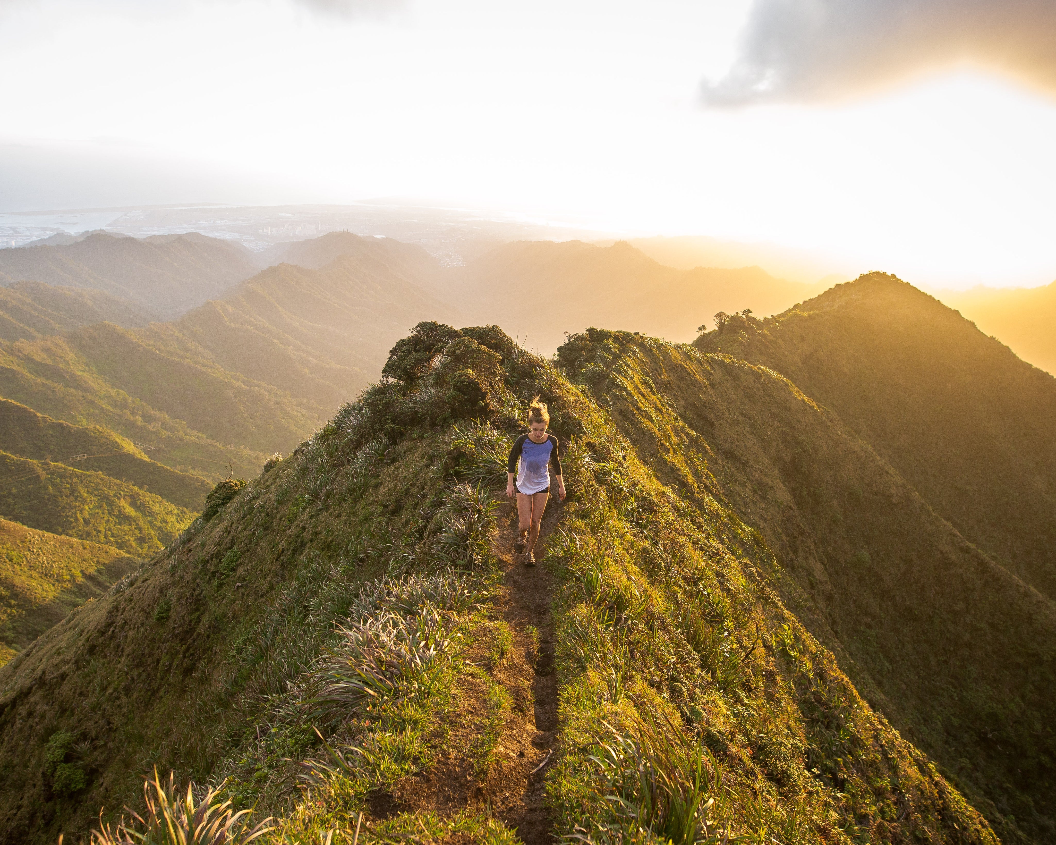 A woman is walking on a hilltop.