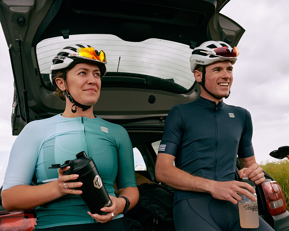 two cyclist resting on the boot of a car with veloforte products