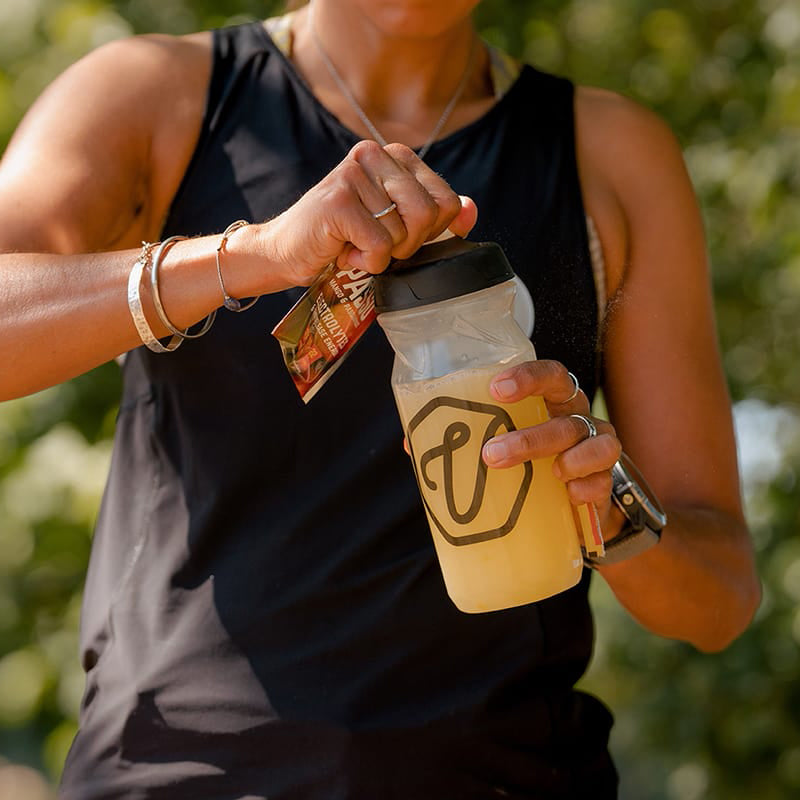 Woman holding water bottle full of electrolytes