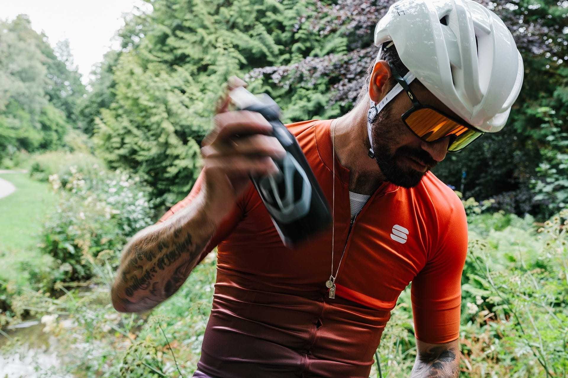 Cyclist shaking a Veloforte water bottle filed with electrolytes