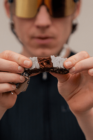 Man breaking Veloforte Protein Bar showing ingredients inside