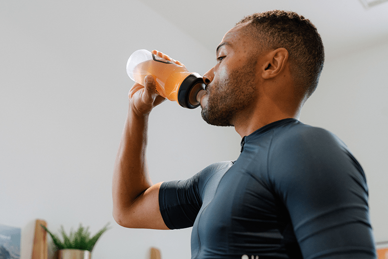 Man drinking Veloforte Electrolyte Powder from a water bottle