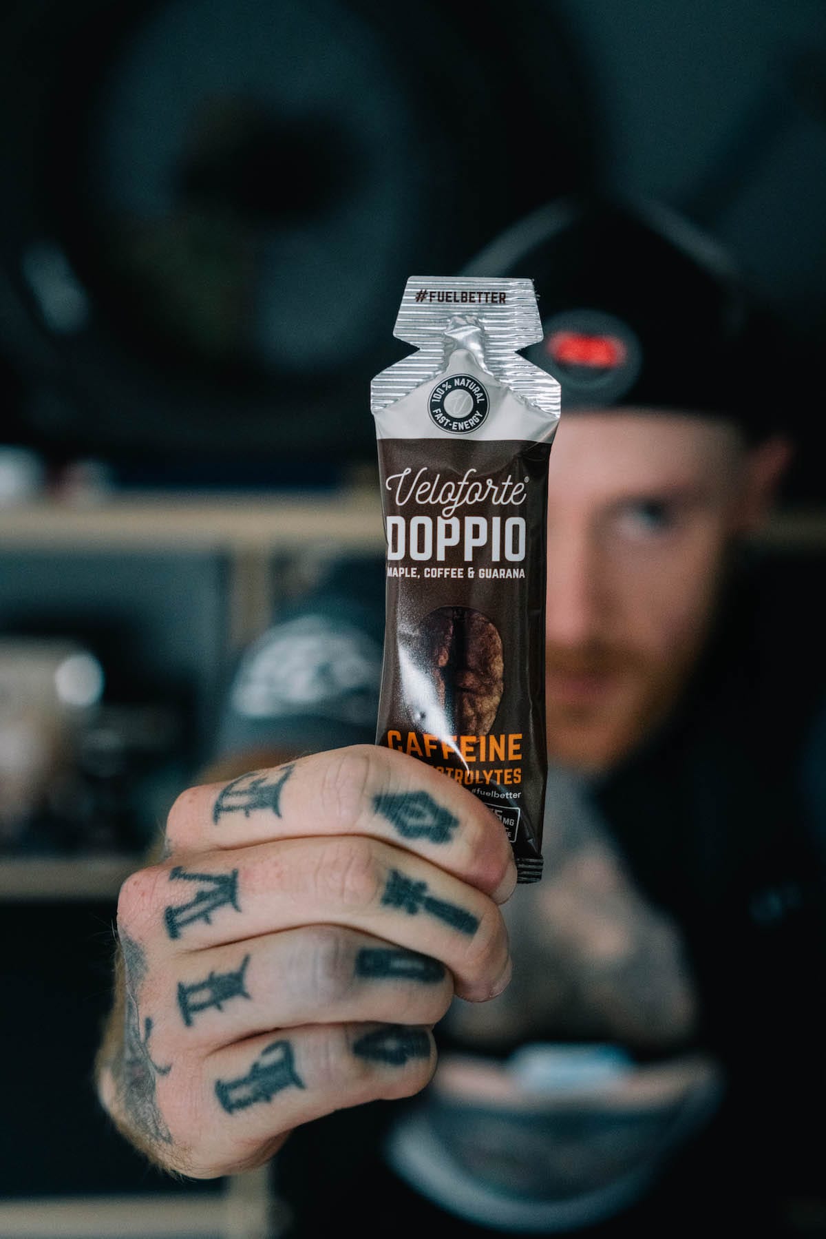 Cyclist Matt holding up Doppio Energy Gel to the camera 