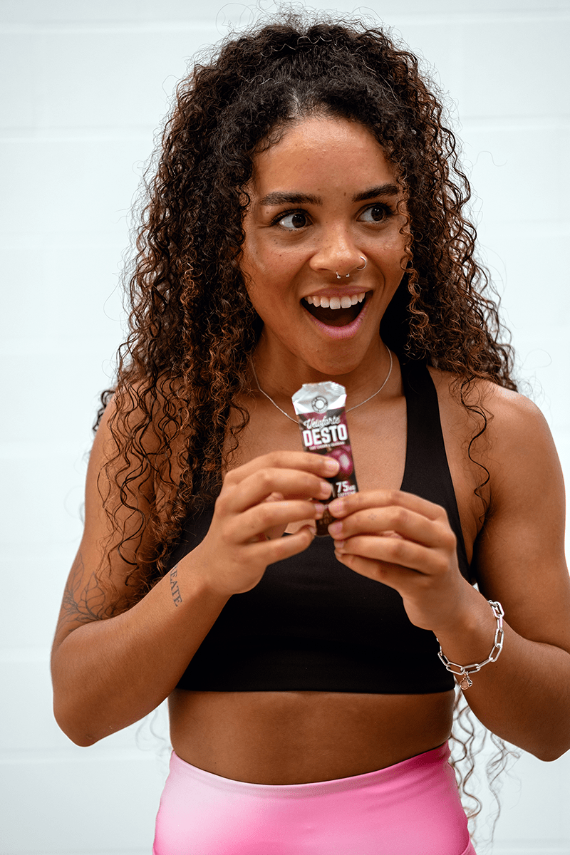 Smiling woman in activewear trying Veloforte Desto Energy Gel