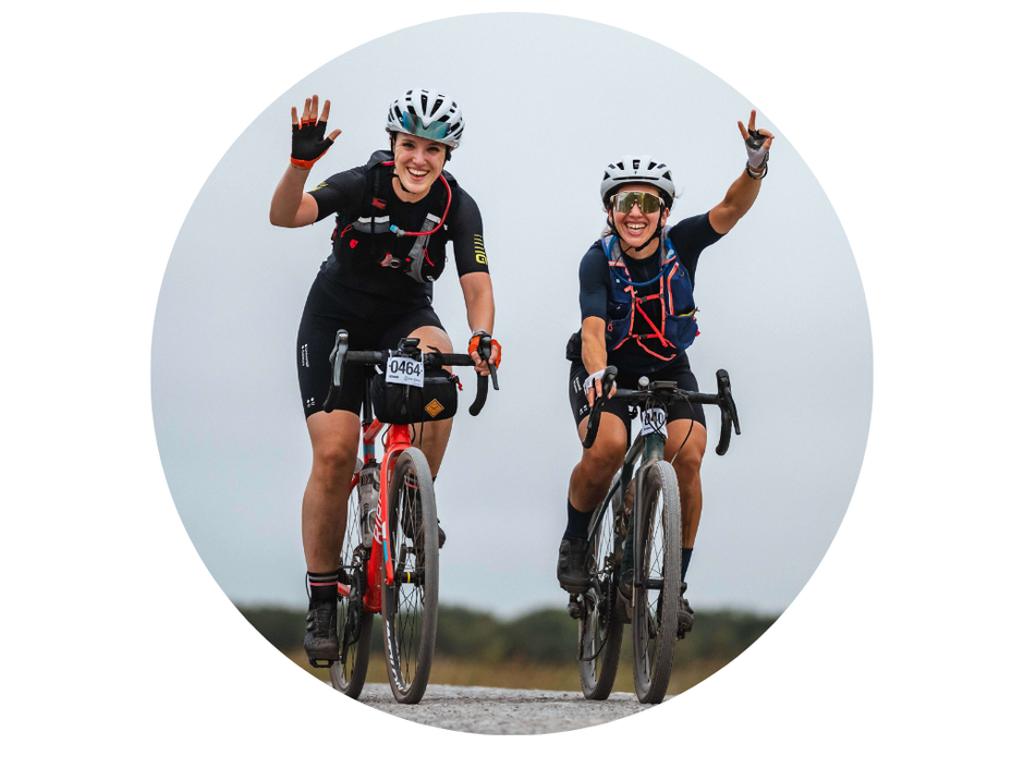 Two cyclists on a road bike with a clear sky background