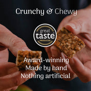 hands holding a oat snack bar with a great taste award producer badge