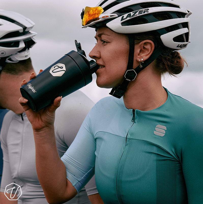 Woman in cycling gear drinking a protein shake