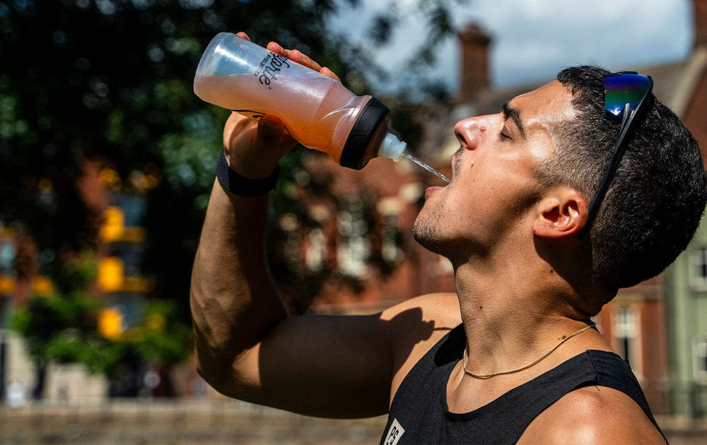 Man drinking from a sports bottle outdoors