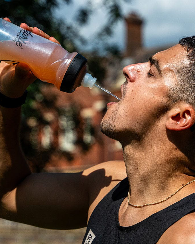 Man drinking from a sports bottle outdoors