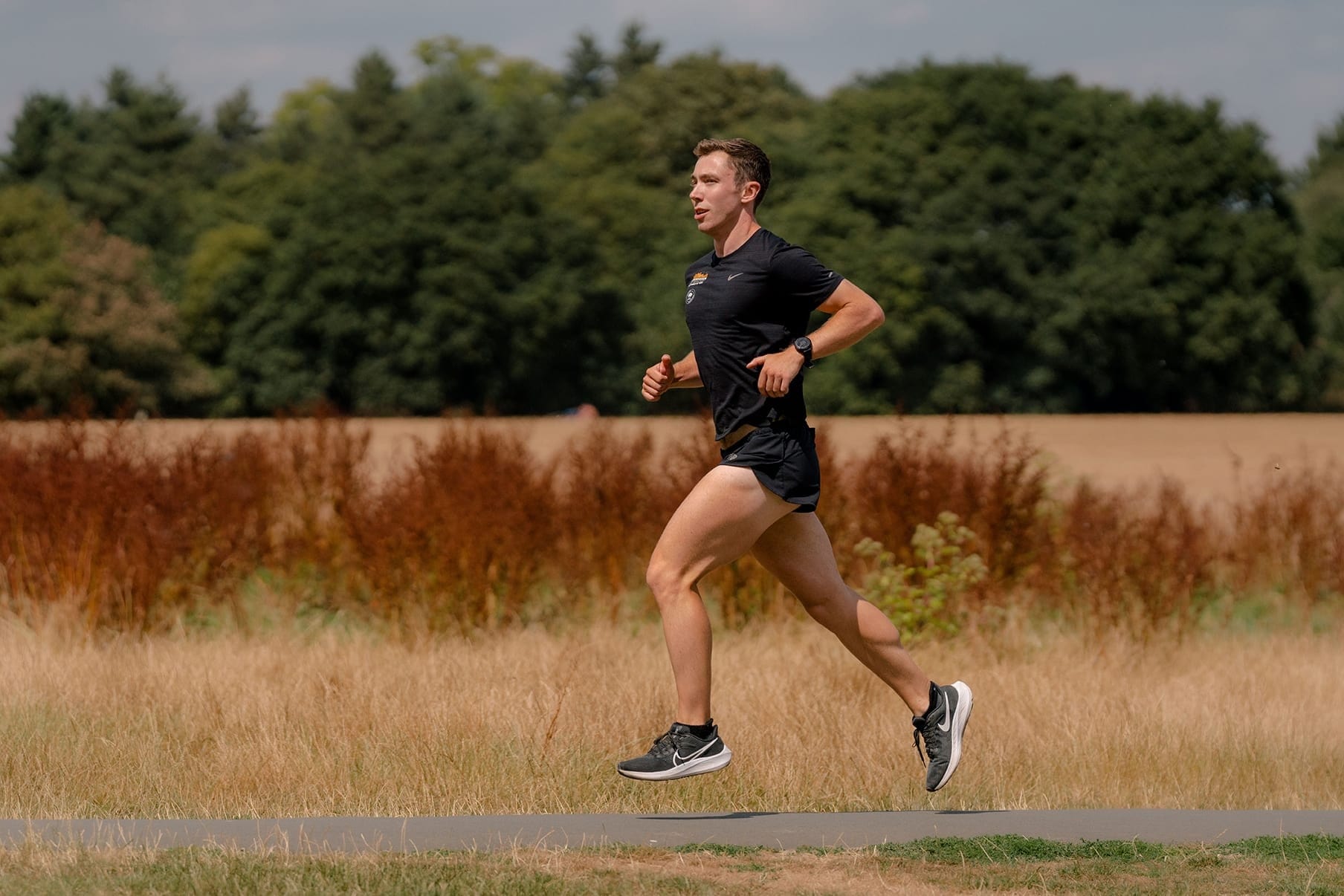 Man running outside along a field on a sunny day